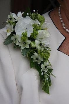 a woman wearing a white dress holding a bouquet of flowers in her lapel cover