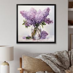 a vase filled with purple flowers sitting on top of a bed