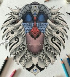 a drawing of a lion's head with many different colored pencils next to it