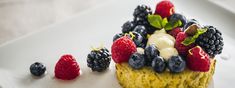 a dessert with berries and cream on a white plate