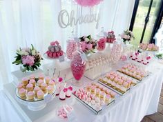 a table topped with lots of cupcakes and cakes