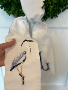 a person holding up a t - shirt with a bird painted on it's back