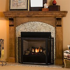 a living room with a fire place in the center and pictures on the wall above it