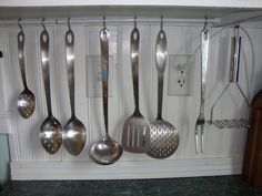 there are many spoons hanging on the wall