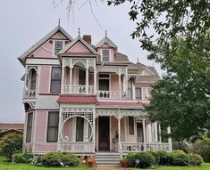 a large pink house with many windows and balconies