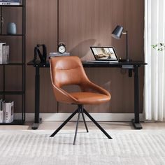 a brown leather chair sitting in front of a computer desk