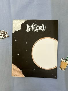 an open notebook with stickers on it next to a drink and some paper clips