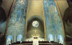 the inside of a church with painted walls and pews