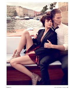 a man and woman sitting on the back of a boat, posing for a magazine cover