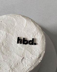 a white cake with black letters that spell out the word bdn on it