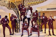 a group of men in maroon suits standing on stairs