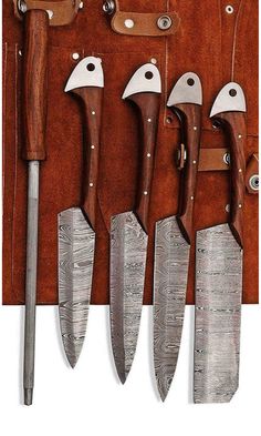 five knives are lined up in a row on a leather case with metal handles and wooden handles