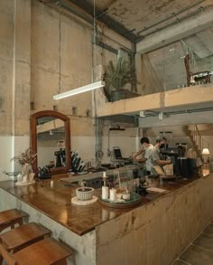 a man working in a commercial kitchen with lots of counter space and stools around the island