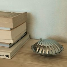 a stack of books sitting next to a silver plate