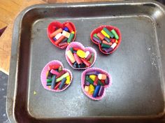 four cupcakes with crayons in them on a pan