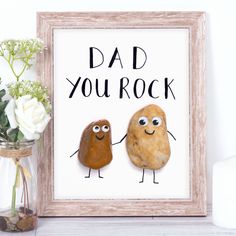 two rocks are holding hands in front of a sign that says, dad you rock