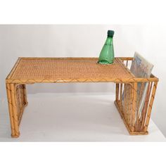 a table made out of bamboo with a green bottle on top and magazines under it