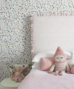 there is a stuffed animal on top of the bed with two other toys next to it