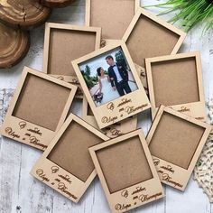 six wooden frames with photos on them sitting next to pine cones and other decorations,