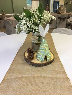 a vase filled with flowers sitting on top of a wooden slice next to a table