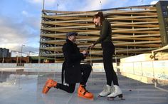 two people sitting on skateboards in front of a building