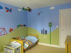 a child's bedroom decorated in blue and green with airplanes painted on the walls