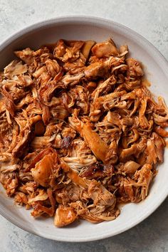 shredded meat in a white bowl on a table