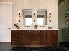 a bathroom with two sinks and mirrors on the wall