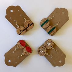 four pieces of wood with red and green beads are arranged in the shape of hearts