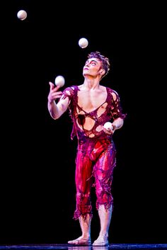 a man juggling balls on stage during a performance