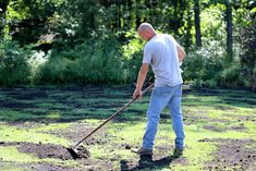 a man using a shovel to mow the grass