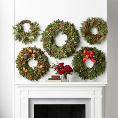 christmas wreaths are hung on the fireplace mantel