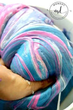 a person holding a blue and pink yarn in a white bowl with text overlay