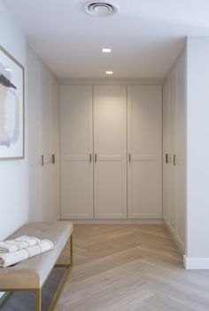 a hallway with white walls and wooden flooring next to a painting on the wall