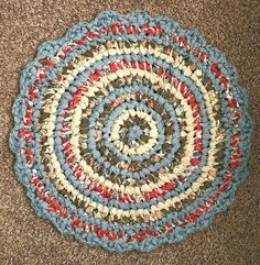 a blue and red rug on the floor with a circular design in it's center