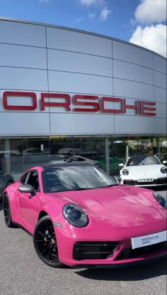 a pink porsche parked in front of a porsche dealership