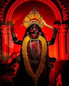 a man dressed in black and yellow is holding his hands up to the side while wearing a headdress