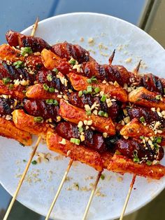 the skewers are covered with meat and sauces on top of rice sticks