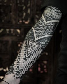 a man's arm with an intricate tattoo design on the forearm and hand area