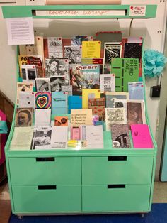 a display case with many different types of books on it's sides and drawers