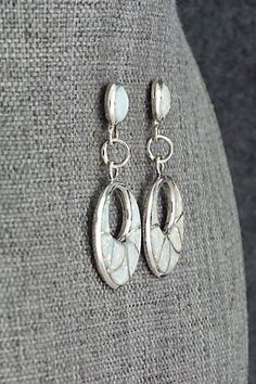 These opalite and sterling silver inlay earrings were made by Zuni silversmith Delorna Lahi. The backs are signed DL.Length: 1 1/2"Width: 3/4"Free shipping on all orders! We ship with USPS and always include tracking. All orders ship within a day of payment.Returns are accepted up to 30 days after you receive your order. Just send us a message. Our shop offers cash back or store credit. The item must be returned in new condition. White Opal Earrings For Pierced Ears, Handmade Opal Earrings In Silver, Elegant Drop Earrings With Inlay, Silver Opal Dangle Earrings, Silver Dangle Opal Earrings, Sterling Silver Jewelry With White Inlay, White Sterling Silver Jewelry With Inlay, White Opal Jewelry With Matching Earrings, Silver Opal Dangle Jewelry