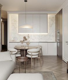 a white living room and dining area with marble walls, wood flooring and furniture