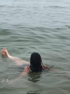 a woman floating in the water with her feet up