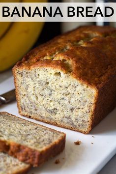 a loaf of banana bread sitting on top of a white cutting board