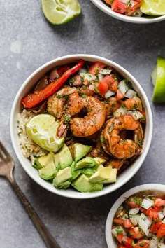 two bowls filled with shrimp, rice and veggies next to lime wedges