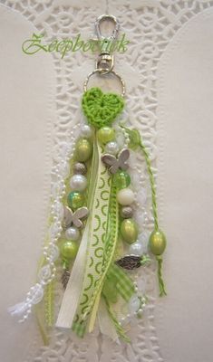 a green and white key chain with beads