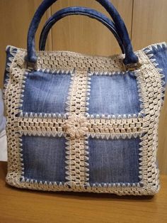 a blue and white purse sitting on top of a wooden table