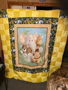 two dogs are laying next to a large quilted elephant and tiger wall hanging on the wall