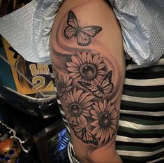 a woman's arm with sunflowers and butterflies on it