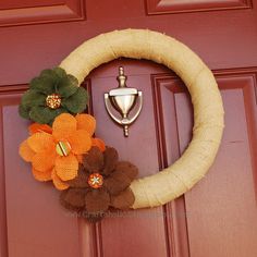 a burlock wreath with flowers on the front door